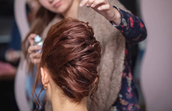 Barbeiro mão segurando os cachos de cabelo marrom no salão de cabeleireiro close-up — Fotografia de Stock