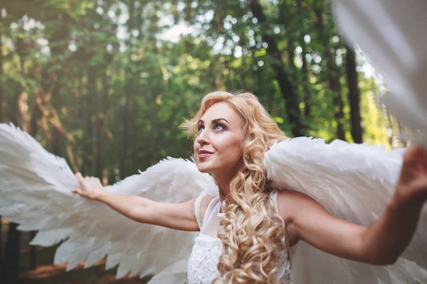 Hermosa modelo joven con alas de ángel blanco al aire libre. Concepto de magia e inocencia — Foto de Stock