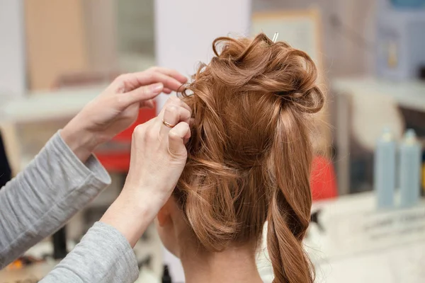 高发型在美发沙龙与优雅发髻中创建过程。金色和红色毛 — 图库照片