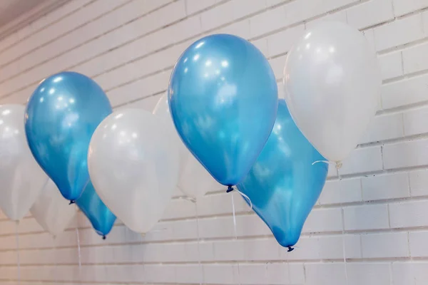 Balónky bílé a modré cihlová zeď pozadí. Koncept dovolené narozeniny — Stock fotografie