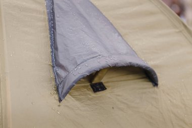 Close up of camping tent ventilation window detail with rain drops. Concept of waterproof cloth clipart