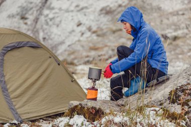 Kaynar su taşınabilir kamp gaz Jet hiking çadır karlı geç sonbahar dağlarda yakınındaki kadın