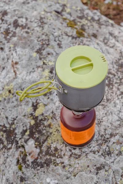 Matlagning på en gasbrännare med kruka i ett läger på en sten — Stockfoto