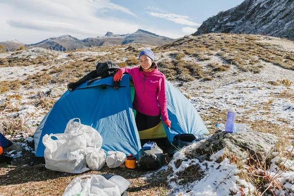 Kobieta w camping z bałagan i rzeczy, Turystyka w zaśnieżonych górach — Zdjęcie stockowe