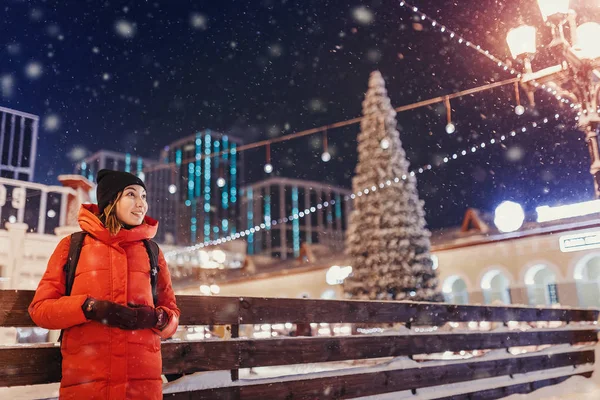 Young woman standing at illuminated square outdoor with christma — Stock Photo, Image