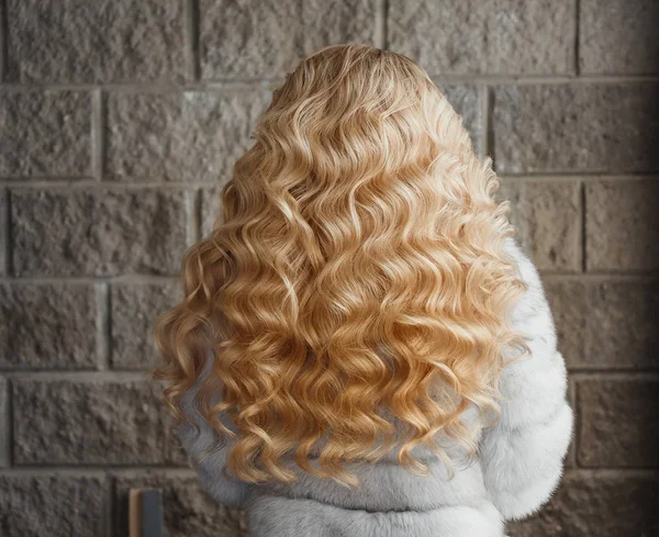 Fille de beauté avec bouclé blonde cheveux ondulés en bonne santé. Vue arrière — Photo