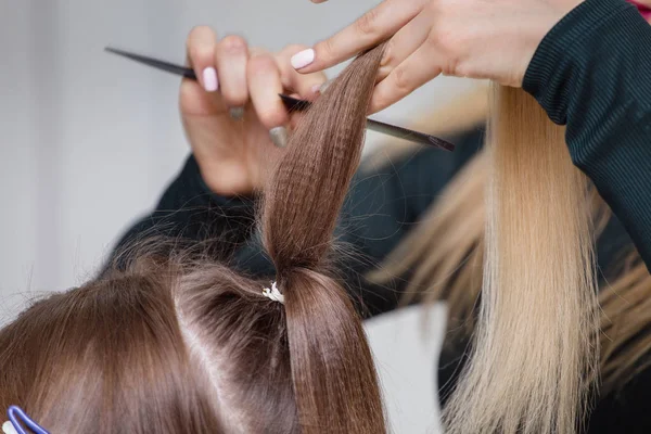 Mãos de mulher pentear o cabelo seu cliente no salão de beleza — Fotografia de Stock