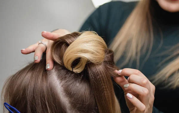 Kapper maakt bovenste broodje kapsel close-up op donkerbruine haren van mooie vrouw — Stockfoto