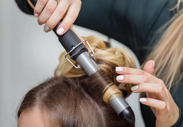 Estilista fazendo argolinhas para mulher morena. Cabeleireiro trabalhando w — Fotografia de Stock