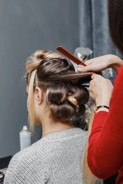 Mãos de mulher pentear o cabelo seu cliente no salão de beleza — Fotografia de Stock