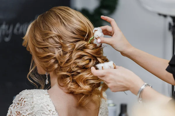 Peluquero o florista hace que la novia un peinado de boda con — Foto de Stock