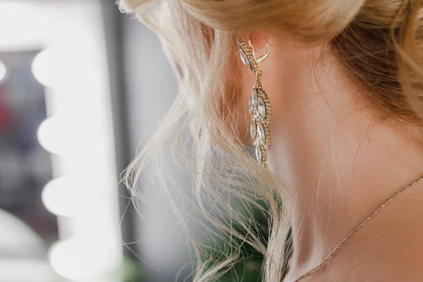 Close-up foco seletivo em brincos de jóias preciosas. Mulher se preparando para o evento, com um penteado chique . — Fotografia de Stock