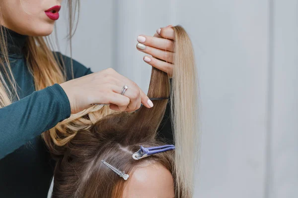 Mains de femme peigner les cheveux et faire bouffant son client dans un salon de beauté — Photo