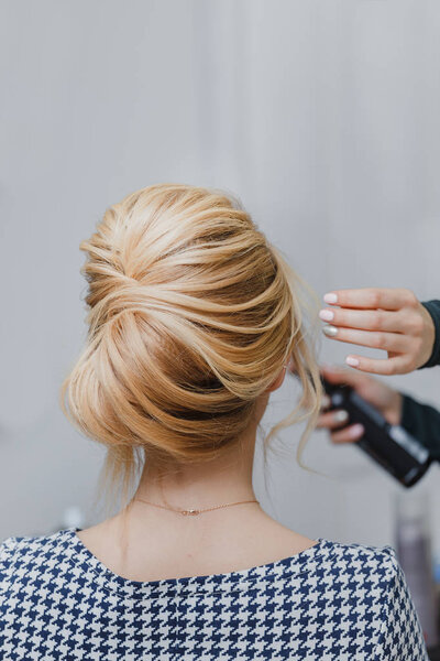 hairdresser doing french twist hairstyle at beauty salon