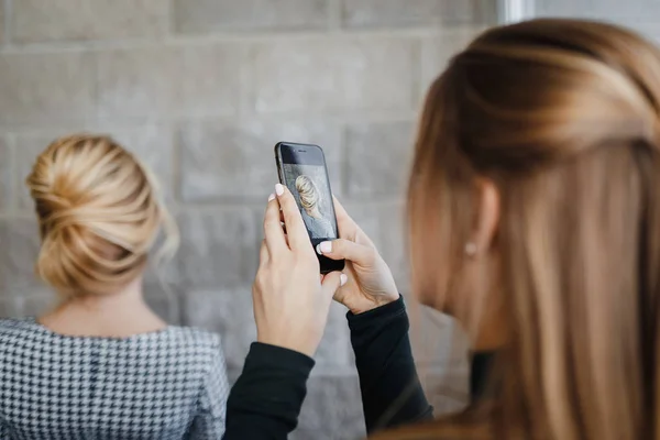 Woman hairdresser taking picture on smartphone of her client hairstyle — Stock Photo, Image