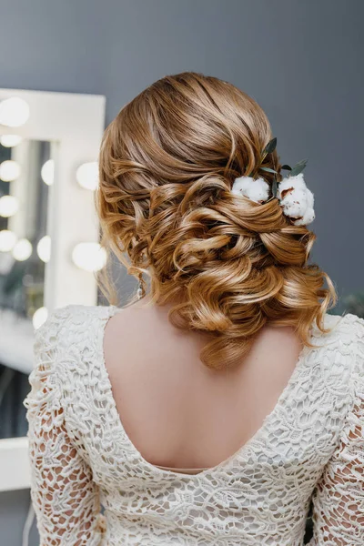 Visão traseira de uma noiva com penteado de casamento encaracolado com flores de algodão como imagem de inverno — Fotografia de Stock