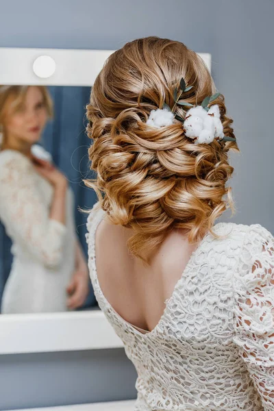 Visão traseira de uma noiva com penteado de casamento encaracolado com flores de algodão como imagem de inverno — Fotografia de Stock