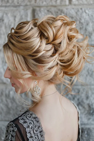 Beautiful female model in a dress and jewelry earrings with evening hairstyle close-up — Stock Photo, Image