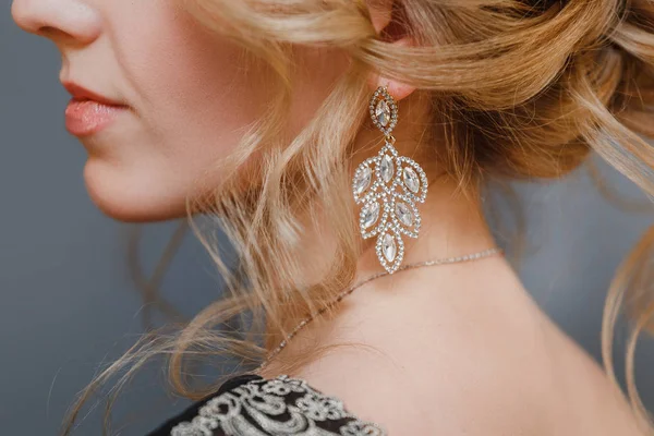 Dettaglio di giovane donna indossa bellissimo orecchino di lusso e acconciatura con spazio copia — Foto Stock