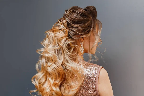 Visão traseira de uma mulher com cabelo tingido com uma bela noite ou penteado de casamento — Fotografia de Stock