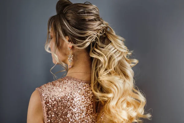 Visão traseira de uma mulher com cabelo tingido com uma bela noite ou penteado de casamento — Fotografia de Stock