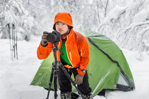 Fiatal szakmai kaukázusi Fényképész-val fényképezőgép állvány a behavazott téli erdőben a — Stock Fotó