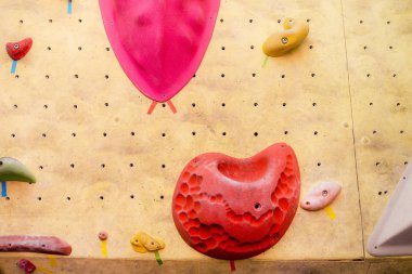 Modern spor salonunun duvarına renkli kancalarla tırmanmak