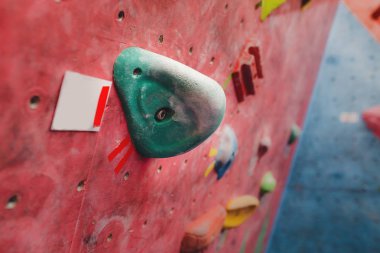 Modern spor salonunun duvarına renkli kancalarla tırmanmak