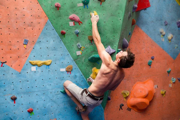 Bonito muscular nu alpinista sem camisa na parede do ginásio — Fotografia de Stock