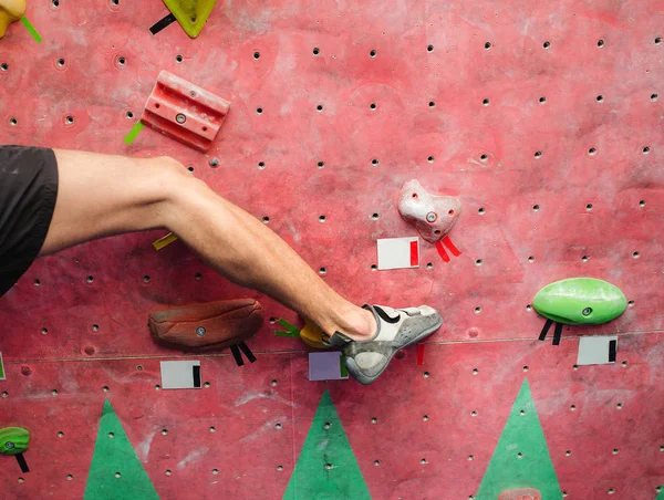 Fot i klättring skor av en man på konstgjord boulder krok i gymmet — Stockfoto