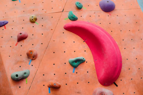 Parede de escalada no ginásio moderno com vários ganchos coloridos — Fotografia de Stock