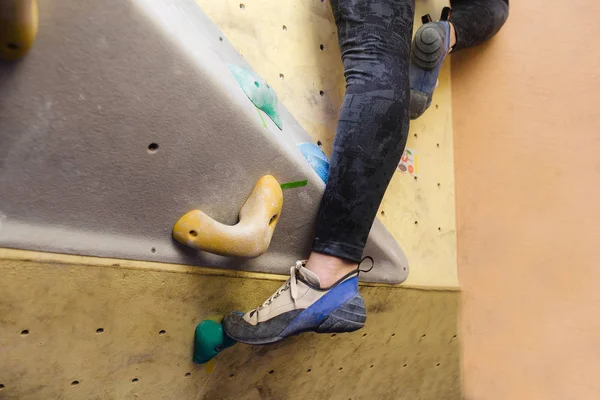 Voet van vrouwelijke klimmer op kunstmatige boulder. Close-up beeld van professionele schoen — Stockfoto