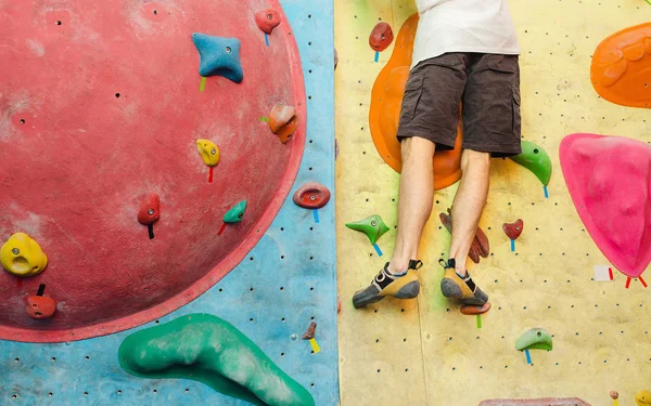 Man klättrar konstgjorda stenblock i gym, närbild av ben med speciella skor — Stockfoto