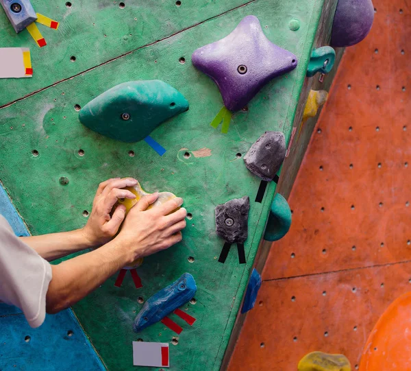 Мышечная рука альпиниста на боулдеринговой стене крупным планом — стоковое фото