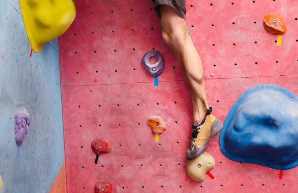 Entraînement d'alpiniste masculin dans le mur de gymnastique de bloc, gros plan des muscles des jambes avec des chaussures — Photo