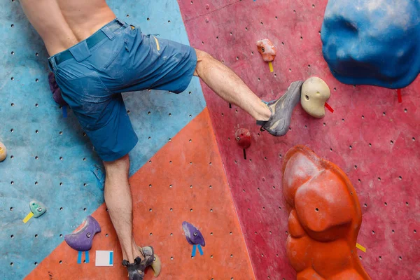 Voet in de schoenen van een man klimmen op kunstmatige boulder haak in sportschool — Stockfoto