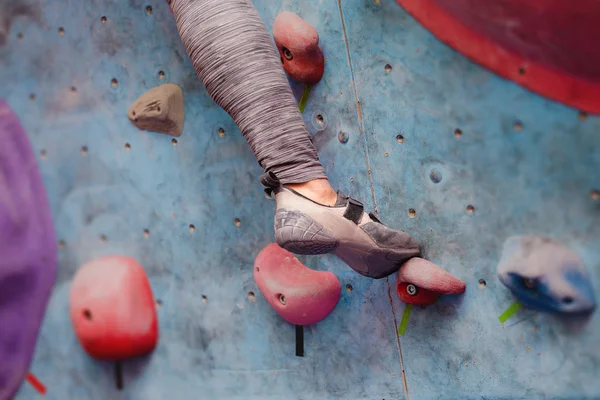 Yapay kaya üzerinde kadın dağcı dibinde. Profesyonel ayakkabı görünümünü yakın çekim