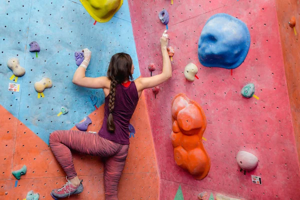 Genç gücü kadın aşırı bouldering içinde modern bir kaya tırmanışı kapalı spor salonu