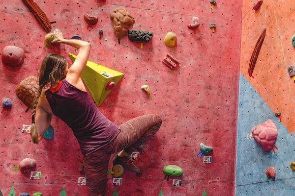 Young strength woman extreme bouldering in a modern rock climbing gym indoors — Stock Photo, Image