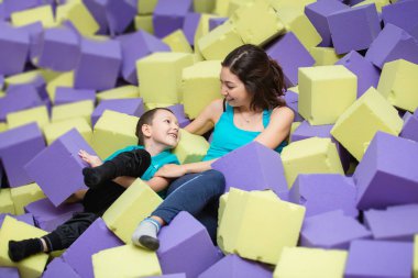 Asya Hint anne ve oğlu kapalı çocuk oyun alanı yumuşak bloklarla oynama.