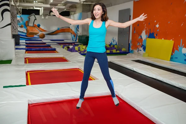 Mujer joven saltando en el centro deportivo trampolín en el interior — Foto de Stock