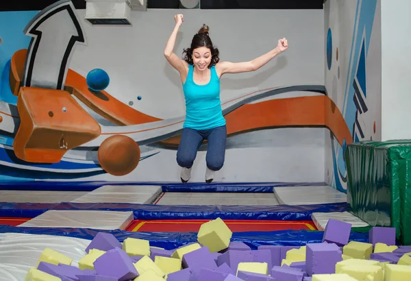 Mladá šťastná žena hraje v dětí foam pit ball — Stock fotografie