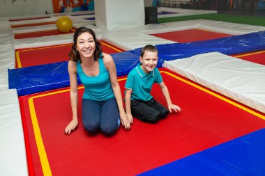 Anne oğluyla paspaslar fitness salonunda katta germe ve trampolines eğitim için hazırlanıyor