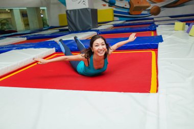 Genç kadın trambolin ve spor salonunda dinlenme atlar