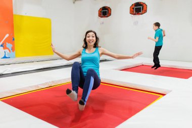 Anne ve oğlu sıçrayan trambolin birlikte kapalı spor salonunda fitness üzerinde.