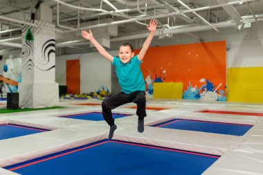 Çocuk spor salonunda trambolinde zıplayan 6 yaşında bir çocuk.