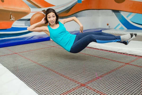 Genç komik Kızılderili kadın düşünüyorsun, spor salonunda trambolin üzerinde atlar