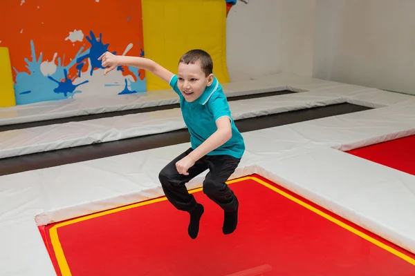 Barn pojke hoppar på studsmatta i fly park — Stockfoto