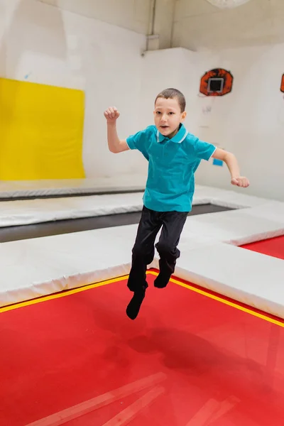 Barn pojke hoppar på studsmatta i fly park — Stockfoto