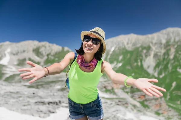 Mujer viajera en las montañas de verano con los brazos extendidos — Foto de Stock
